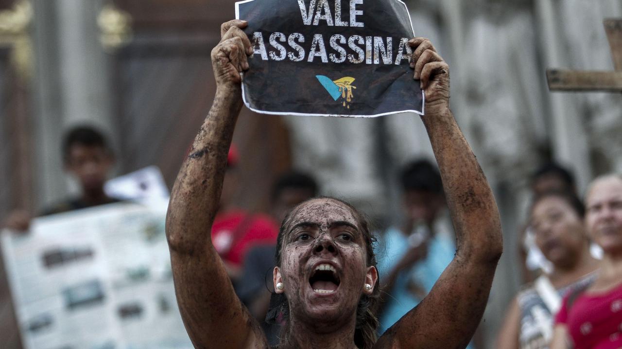 A protester covered in mud and holding a sign reading ‘Vale murderer’ takes part in a demonstration in front of the Se Cathedral in Sao Paulo, Brazil, on February 1. Picture: Miguel Schincariol/AFP