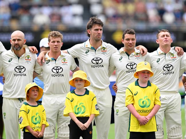 BRISBANE, AUSTRALIA - DECEMBER 14: (L-R) Nathan Lyon and Nathan McSweeney Mitch Marsh, Alex Carey, Marnus Labuschagne and Usman Khawaja of Australia line up for national anthems prior to day one of the Third Test match in the series between Australia and India at The Gabba on December 14, 2024 in Brisbane, Australia. (Photo by Bradley Kanaris/Getty Images)