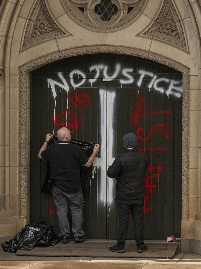 Workers cover graffiti at St Patricks Cathedral in Melbourne.