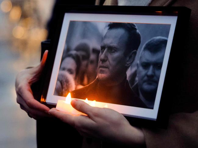 A protester holds candles and a picture of the late opposition leader Alexei Navalny, during a demonstration in Paris. Picture: AFP