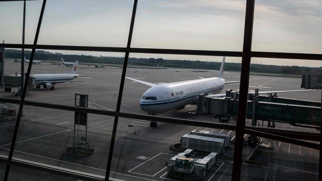 An Air China plane sits on the tarmac at terminal three in Beijing's Capital International Airport, which is nearly empty due to the coronavirus outbreak in Beijing earlier this year. Picture: AFP