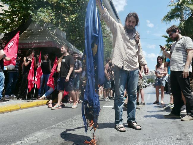 Tensions ... Leftist protesters try to burn a EU flag in front of European commission offices in Athens. Picture: Louisa Gouliamaki/AFP