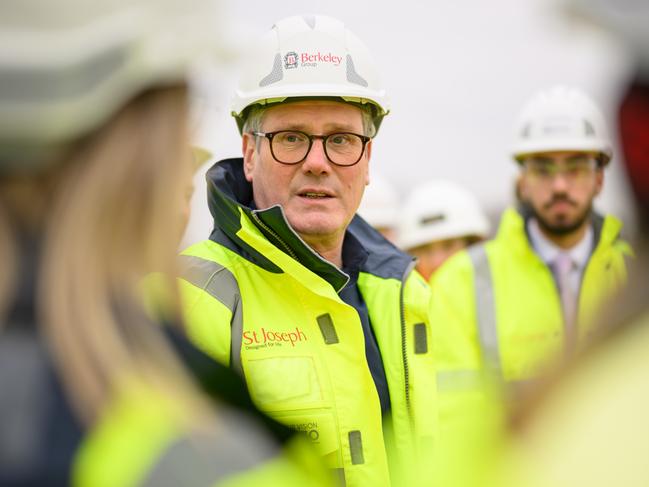 NEWPORT PAGNELL, ENGLAND - FEBRUARY 13: Prime Minister Sir Keir Starmer views plans and speaks with apprentices during a visit to the housing construction development of Elverby, near Newport Pagnell on February 13, 2025 in Buckinghamshire, England. The visit was to promote new plans to build twelve new towns modelled on King Charles III's housing developments, with some potentially being located on current green-belt land. The visit was cut short due to an unplanned protest by farming groups, blocking the nearby roads with tractors. (Photo by Leon Neal - WPA Pool/Getty Images)