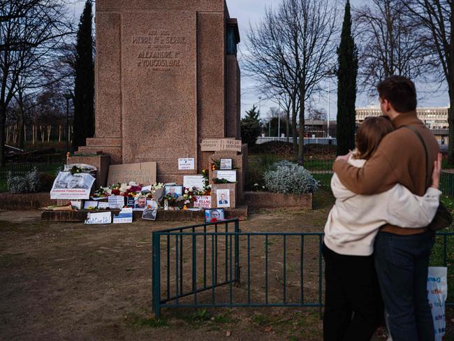 A couple hug as they pay homage to Alexei Navalny next to the Russian embassy in France. Picture: AFP