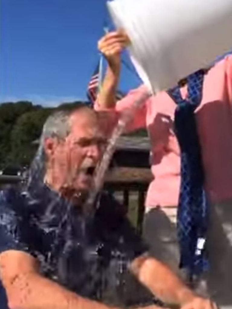 George W. Bush has a bucket of cold water poured over his head by wife Laura.