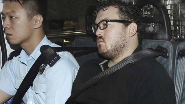 Rurik George Caton Jutting, right, is escorted by a police officer in an police van before appearing in a court in Hong Kong Monday, Nov. 3, 2014. Hong Kong police said Monday that they had charged the 29-year-old man with killing two women, including one whose body was found inside a suitcase on the balcony of the man's upscale apartment. (AP Photo/Apple Daily) HONG KONG OUT, TAIWAN OUT, NO ARCHIVE