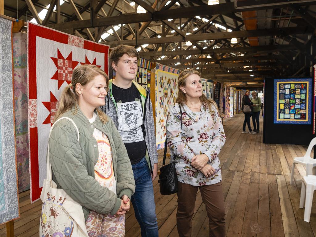 Checking out the work on show by Toowoomba Quilters Club members are (from left) Amber Cook, Keegan Zischke and Janine Zischke at Craft Alive at the Goods Shed, Sunday, May 22, 2022. Picture: Kevin Farmer