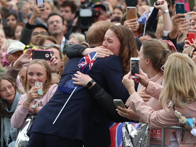 Prince Harry hugged India Brown, 19, earlier in the day outside Government House. Picture: Alex Coppel