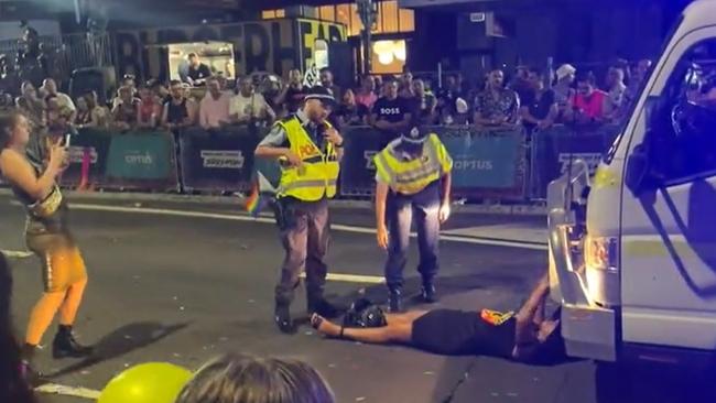 Stills from a video of Senator Lidia Thorpe who laid down in front of the Australian Federal Police float during the Sydney Mardi Gras causing a short disruption to the parade.