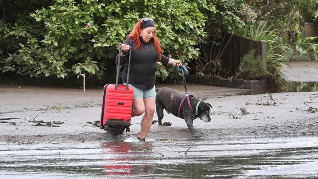 Antoinette Bufalino crosses floodwater in Maribyrnong. Picture: David Crosling