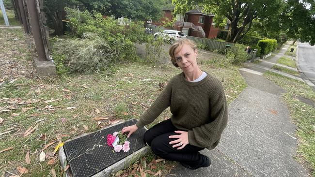 Sharon Arens lays flowers at the scene.