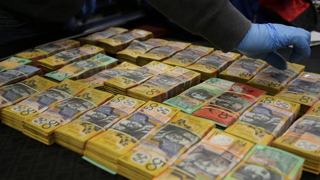 Police seized stacks of cash during raids on a Seven Hills business and homes across Sydney. Picture: AFP