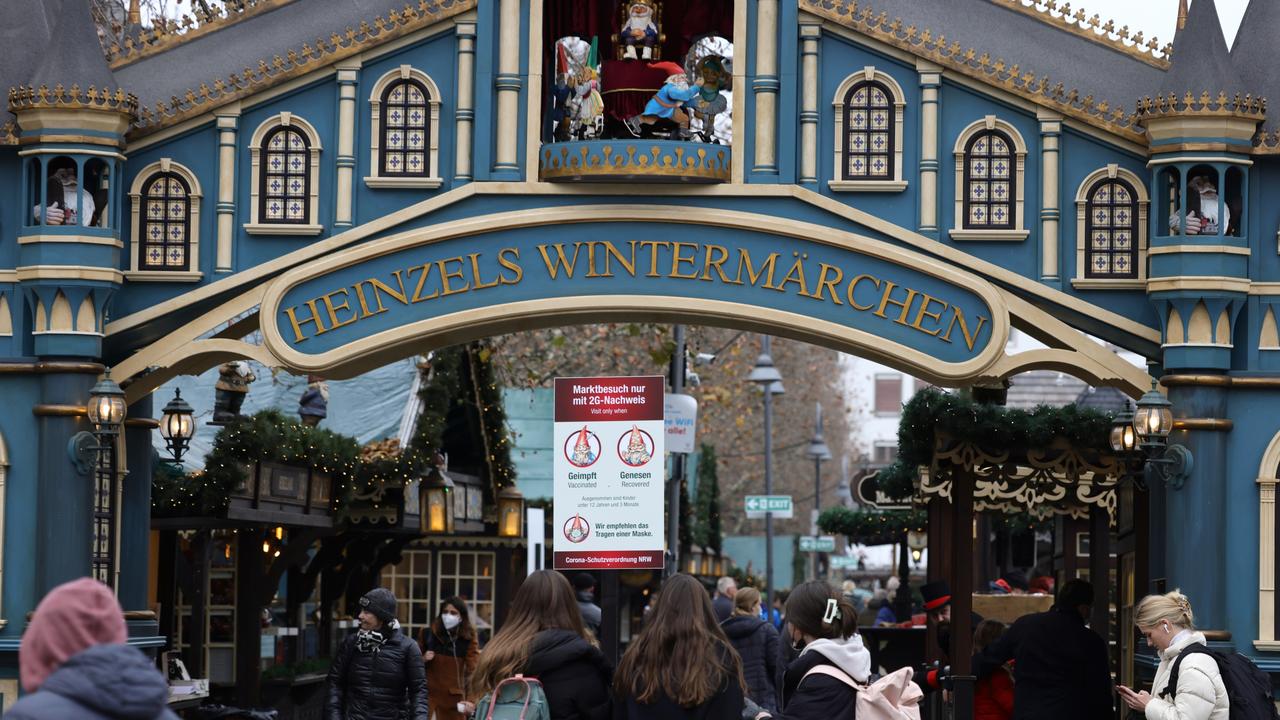 Visitors past a sign that shows 'Visit only to people vaccinated against or recently recovered from Covid-19 … not to people who are unvaccinated' at a German Christmas market. Picture: Andreas Rentz/Getty Images