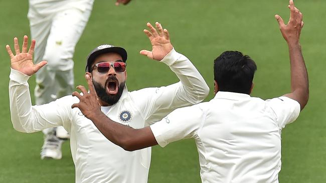 India's captain Virat Kohli (L) celebrates with spin bowler Ravichandran Ashwin