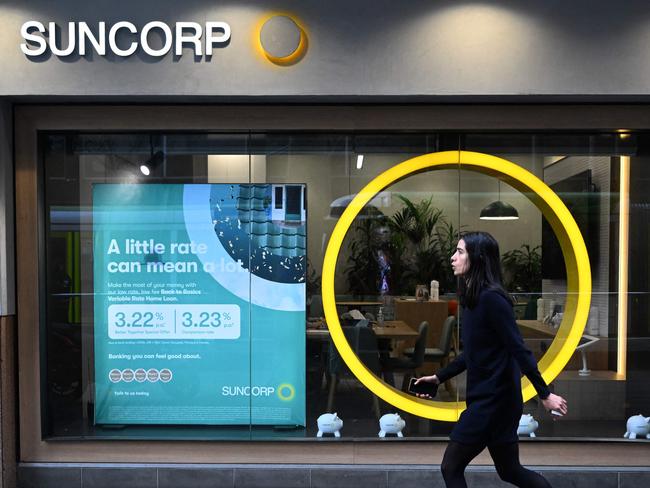 A pedestrian walks past a Suncorp Bank branch in Melbourne on July 18, 2022. - Australian banking giant ANZ announced on July 18 a 3.3 billion USD deal to swallow regional lender Suncorp Bank -- one of the biggest takeovers in the sector for more than a decade. (Photo by William WEST / AFP)