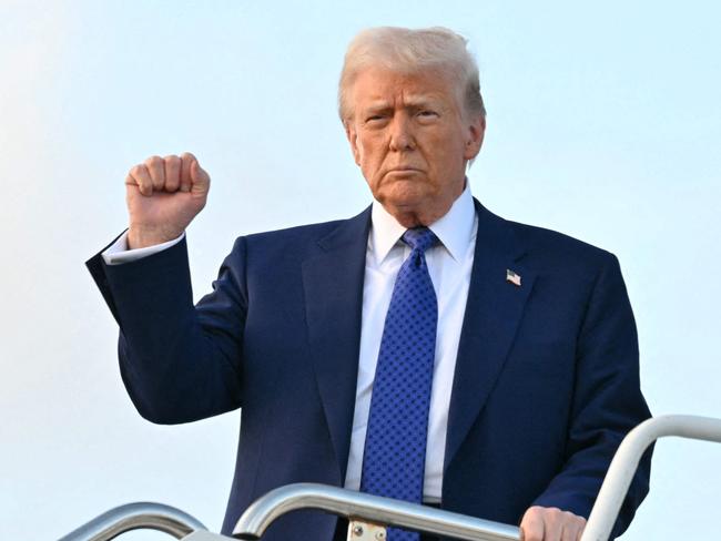 US President Donald Trump pumps his fist as he steps off of Air Force One upon arrival at Palm Beach International Airport in West Palm Beach, Florida, on February 14, 2025, en route to his Mar-a-Lago resort. (Photo by ROBERTO SCHMIDT / AFP)