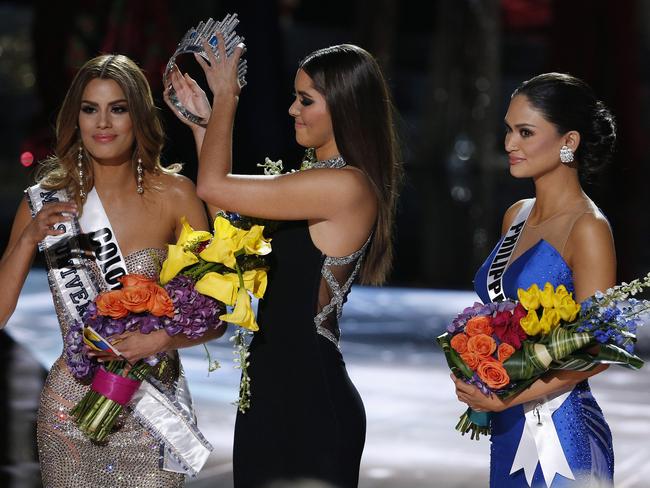 Former Miss Universe Paulina Vega ... removes the crown from Miss Colombia Ariadna Gutierrez before giving it to Miss Philippines Pia Alonzo Wurtzbach. Picture: AP