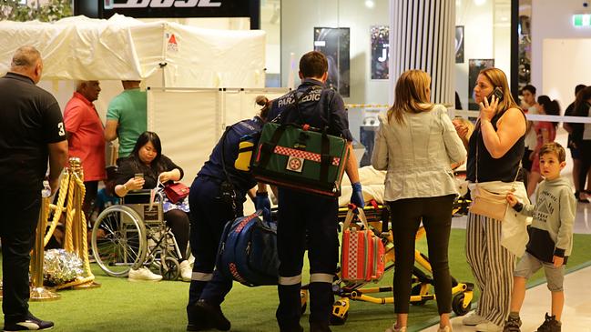 Paramedics tend to an injured woman at the scene. Picture: Bill Hearne