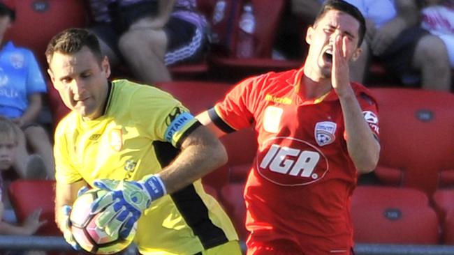 Adelaide United’s Dylan McGowan clashes with Brisbane Roar keeper Michael Theo at Coopers Stadium. McGowan says he has been taunted by rival clubs’ fans over his father’s murder conviction. Picture: David Mariuz (AAP)