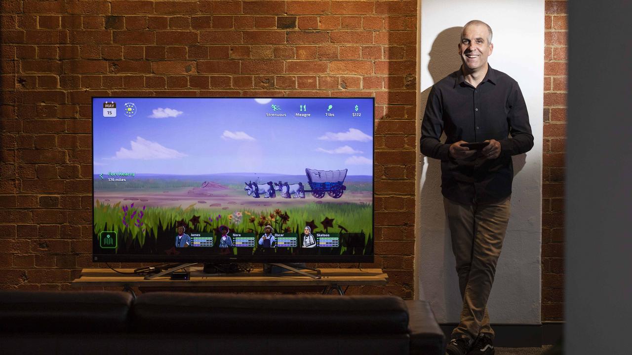 Dylan Miklashek, who runs Brisbane's Gameloft Studio, with the Oregon Trail app. The studio recently put out a new Oregon Trail app through Apple Arcade. Picture: Mark Cranitch