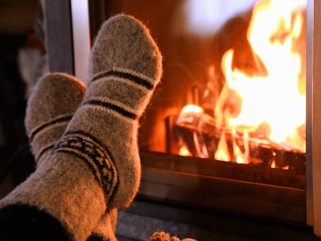 Feet in wool socks warming at the fireplace.Escape 2 June 2024DestinationsPhoto - iStock