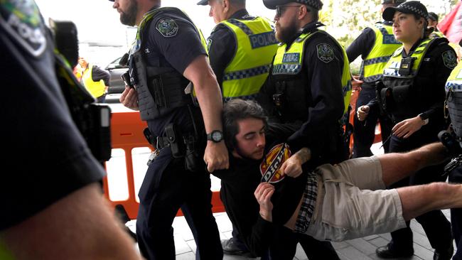 Extinction Rebellion protesting at the Convention Centre, Adelaide, on Tuesday. Police arrest a protester for breaching the barrier. Picture: Tricia Watkinson