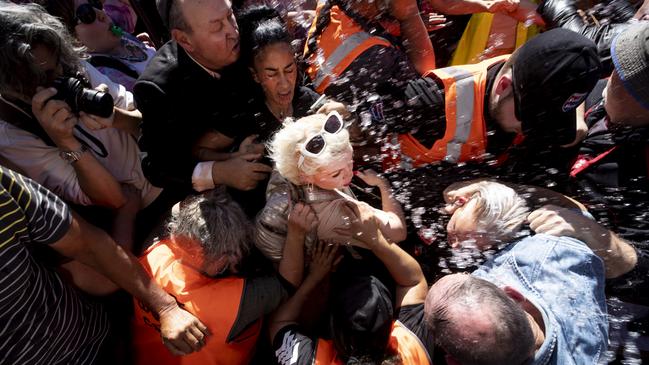 Kellie-Jay Keen-Minshull (Posie Parker) is escorted from Auckland’s Albert Park as trans-rights supporters attempt to attack her. Picture: Dean Purcell