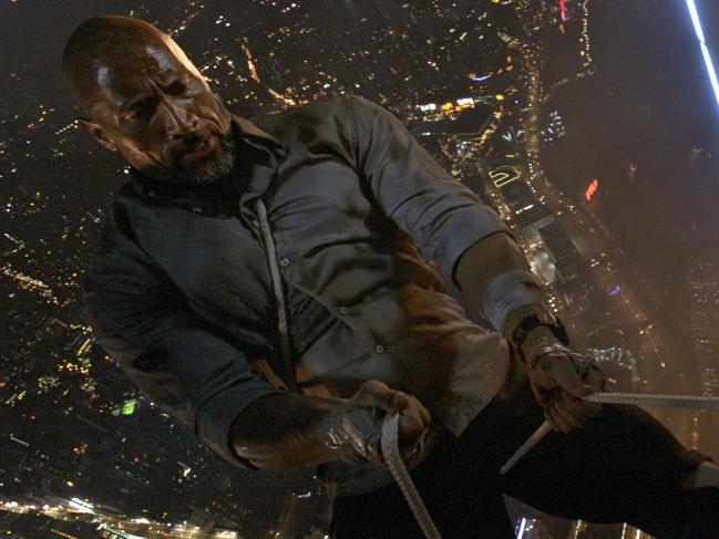 Dwayne Johnson rappels down the side of the world's tallest building in a scene from film Skyscraper