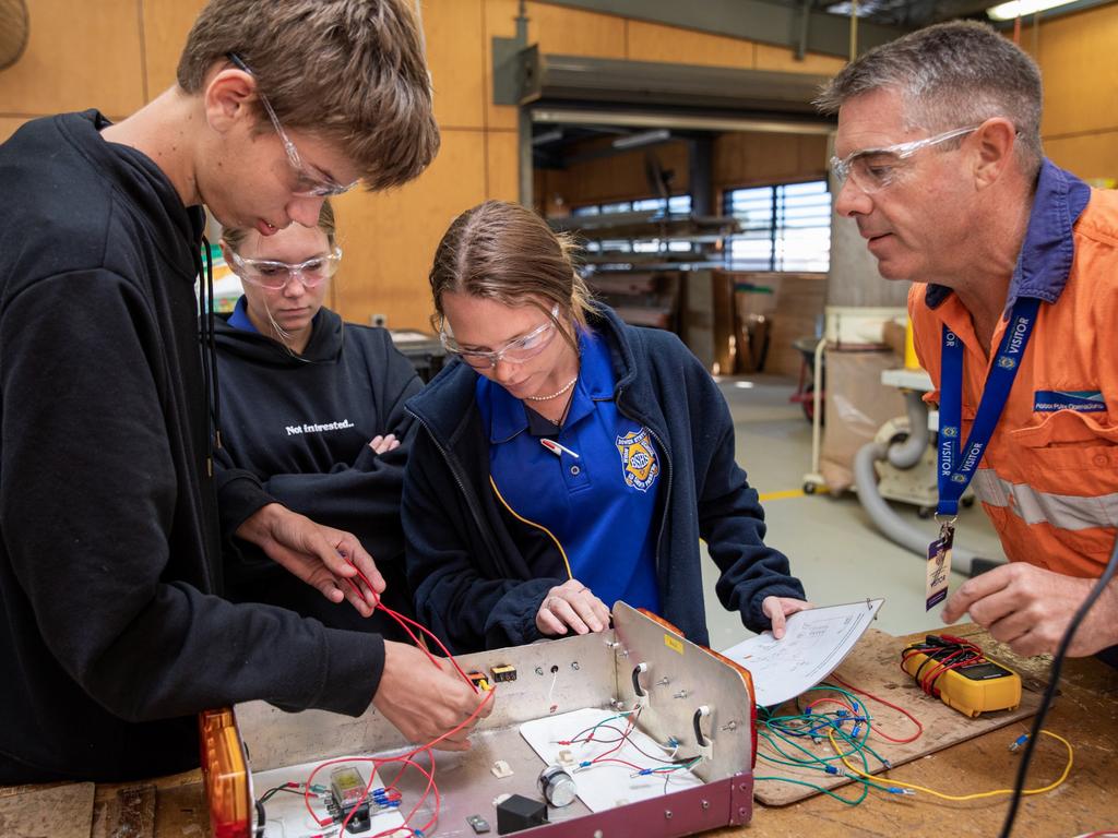 Abbot Point Operations Electrician Glenn Dunkerton (right) instructs Bowen State High School students at the QMEA's Tradie for a Day workshop