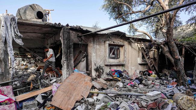 A Palestinian man walks on the rubble of a destroyed house in Nuseirat following Israeli bombardment overnight on May 23, 2024, amid continuing battles between Israel and Hamas in the Gaza Strip. (Photo by Bashar TALEB / AFP)