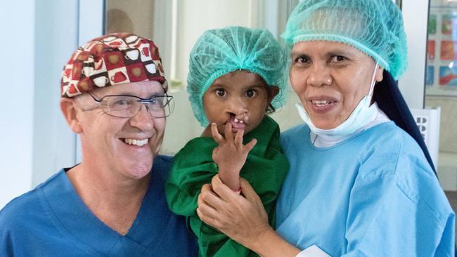 Dr Mark Moore, medical head of the Australian Craniofacial Unit, with a patient in East Timor.