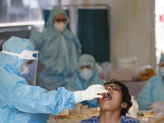 A health worker takes a swab test at a COVID-19 testing centre. Picture: AP