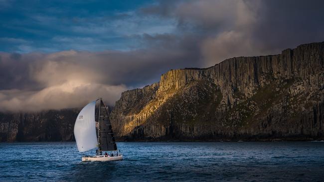 Midnight Rambler passing the dramatic backdrop of Tasman Island, on Tasmania’s wild southern coast with its dolerite cliffs, as featured in Blue Water Classics. Picture: ANDREW WILSON