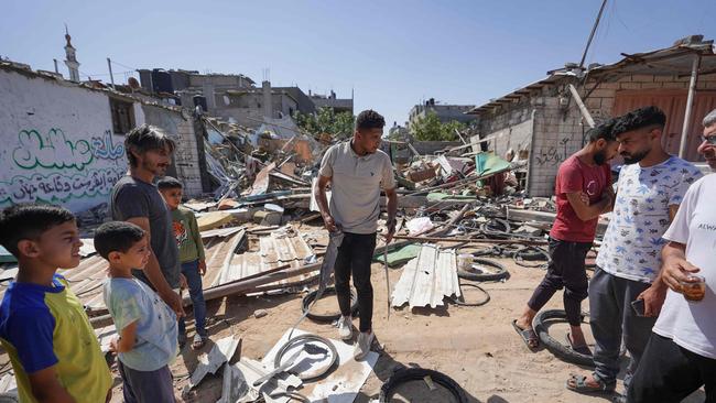 Palestinians salvage items from the rubble of a family home following Israeli strikes in the Nuseirat refugee camp. Picture: AFP