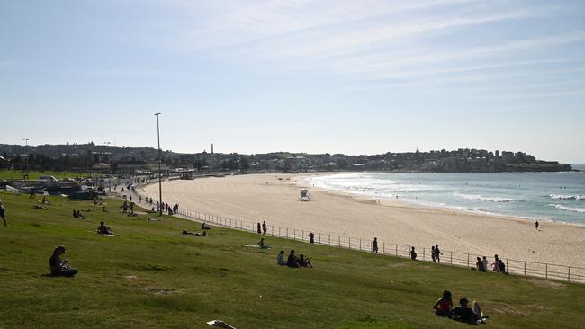 Beachgoers keeping distance on the grass at Bondi Beach in Sydney last Sunday after tens of thousands drew condemnation for flooding the beach days earlier. Picture: Joel Carrett/AAP