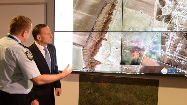 Assistant AFP commissioner Michael Outram shows Prime Minister Tony Abbott an aerial view of the MH17 crash site during a visit to the co-ordination centre at the AFP headquarters in Canberra in 2014. Picture: AAP.