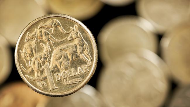 Australian one dollar coin over blurred golden background.