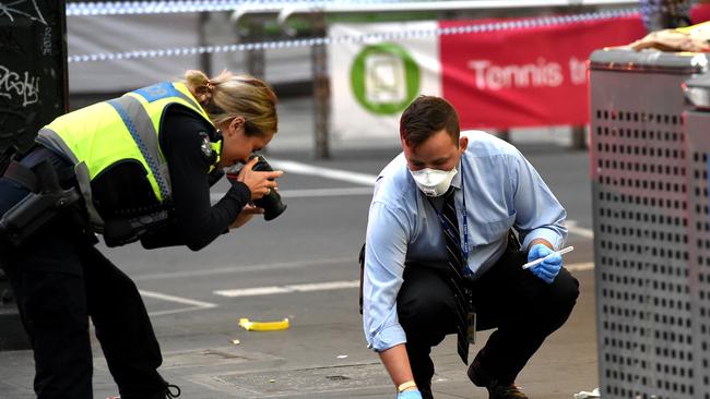 Police take swabs of blood from the footpath. Picture: Nicole Garmston