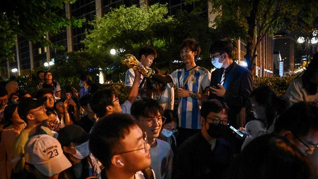 Chinese fans react after they catch a glimpse of the Argentine national football team outside a hotel where the team is staying in Beijing.