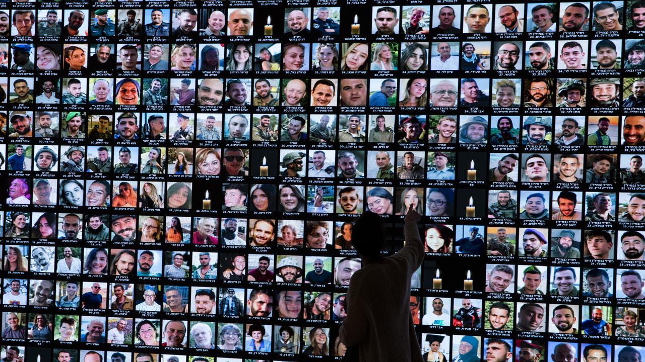 A woman looks at a screen of photos of those killed during the Oct 7 Hamas attack and soldiers killed in the war in Gaza at the National Library of Israel (Photo by Amir Levy/Getty Images)