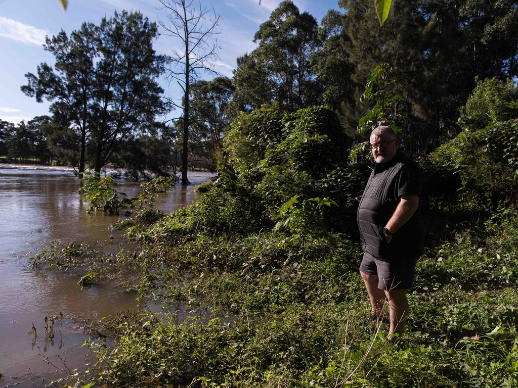 Declan Murphy standing in front of roads submerged under floodwater from the swollen Hawkesbury River, in north Richmond. Sydney: Picture: NewsWire / Flavio Brancaleone