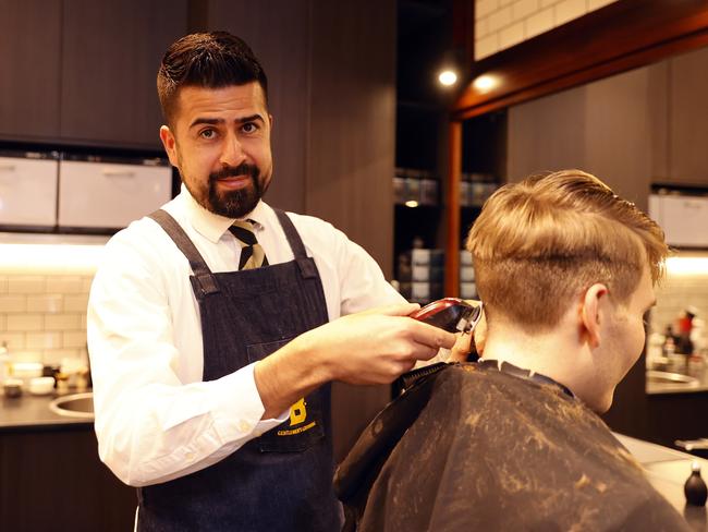 Barber Jonatas Correia at Barberhood in Martin Place in Sydney is still feeling the effects of the slow return to the CBD. Picture: Tim Hunter.