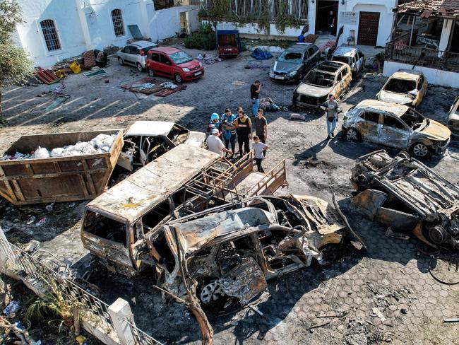 This aerial view shows people standing before destroyed buildings at the site of the Ahli Arab hospital in central Gaza. Picture: AFP