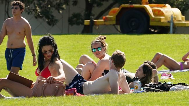 People sunbathe at St Kilda Beach in Melbourne on Saturday. Picture: AAP.