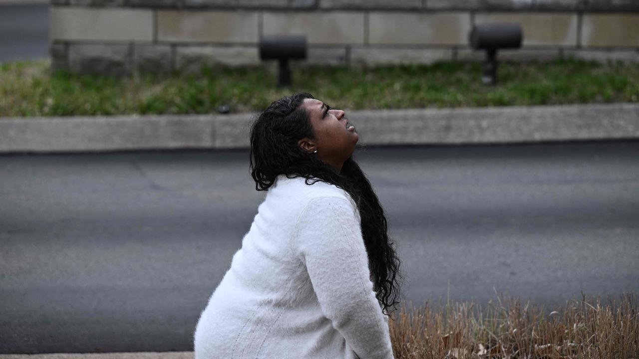 A woman pays her respects at a makeshift memorial for victims outside the Covenant School. (Photo by Brendan SMIALOWSKI / AFP)