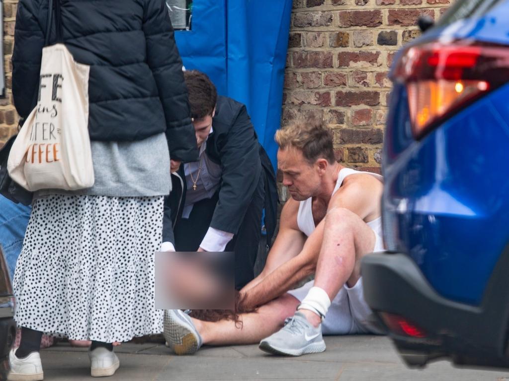 The Neighbours star propped the woman’s head up on his leg. Picture: BACKGRID.