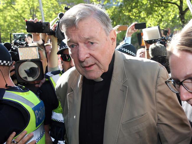 (FILES) This file photo taken on February 27, 2019 shows Australian Cardinal George Pell (C) making his way to the court in Melbourne. - Cardinal George Pell will walk free from jail after winning a long-running battle to overturn his child sex abuse convictions in Australia's High Court on April 7, 2020. (Photo by Con CHRONIS / AFP)