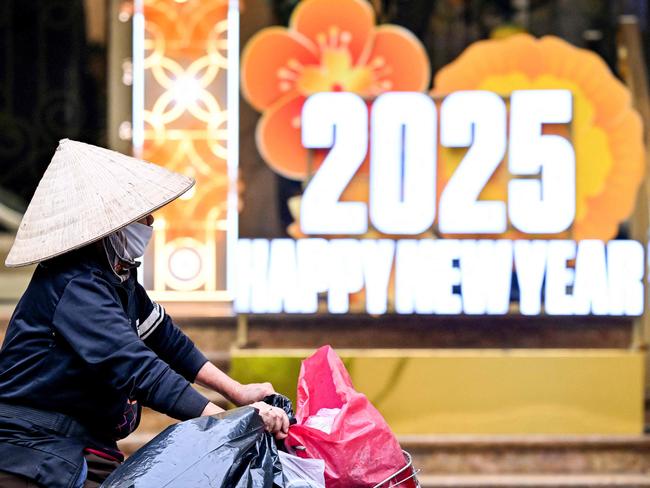 A woman rides her bicycle past New Year 2025 numerals displayed in Hanoi on December 31, 2024. Picture: AFP