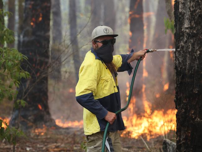 Fire in the small coastal town of Berrara, near Sussex Inlet today. Firefighters and locals fought a bush fire near houses. Picture: David Swift.