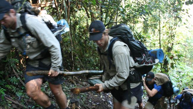 Hawthorn players Stuart Dew and Brendan Whitecross lead the stretcher gang along the Kokoda Track during a Hawks preseason camp.